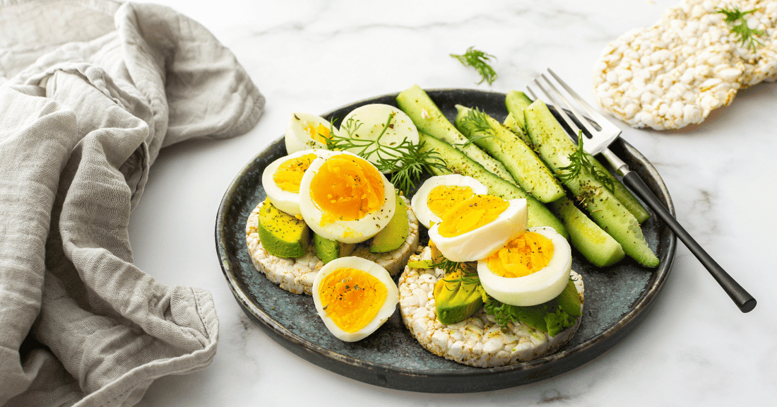 Hard boiled eggs served with rice cakes and avocado.