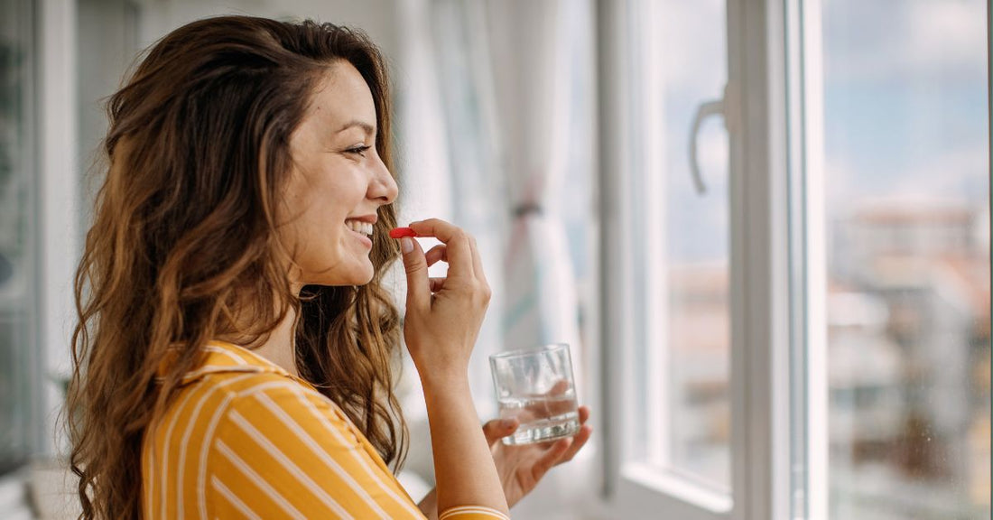 A woman takes a red iron supplement.