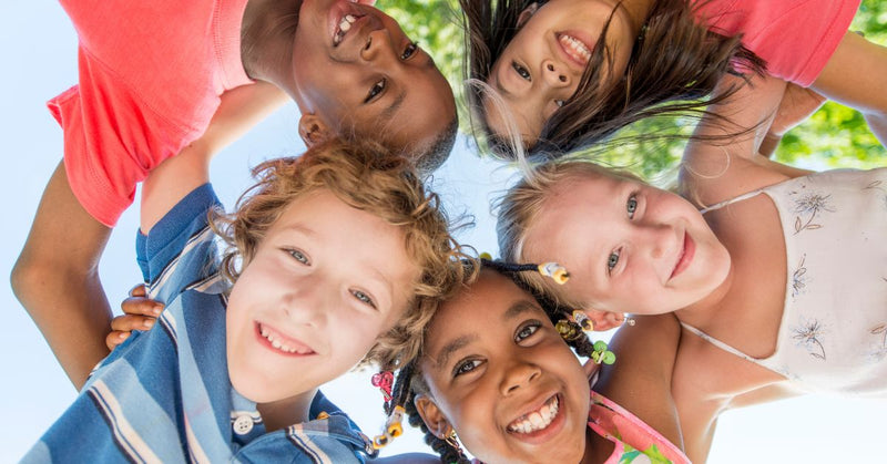 Five kids huddle together during summer.