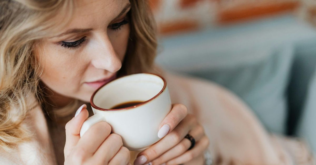 A woman drinks a cup of tea.