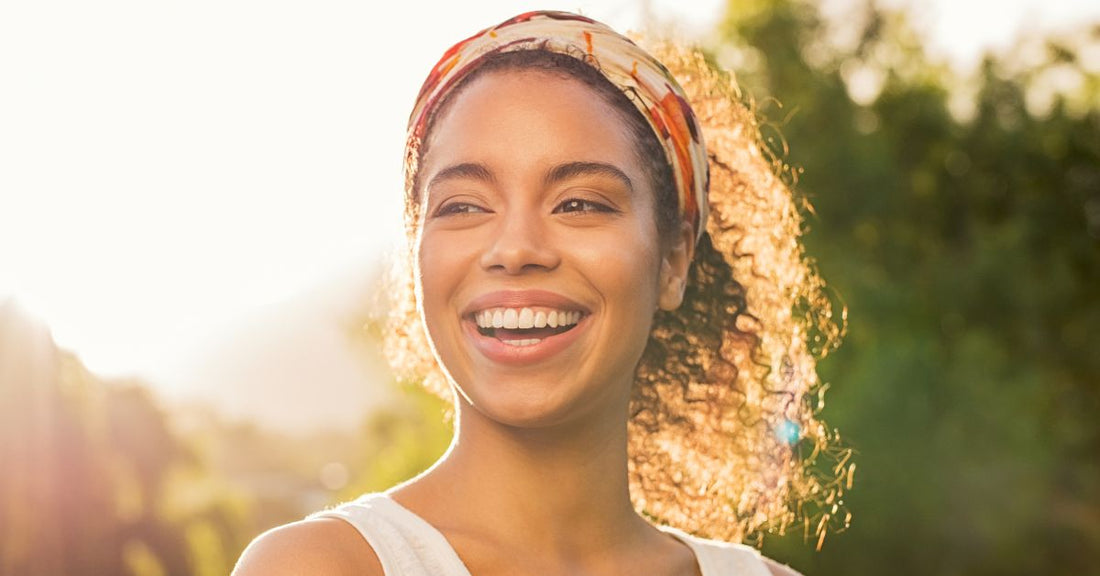 A woman smiles while out in nature.