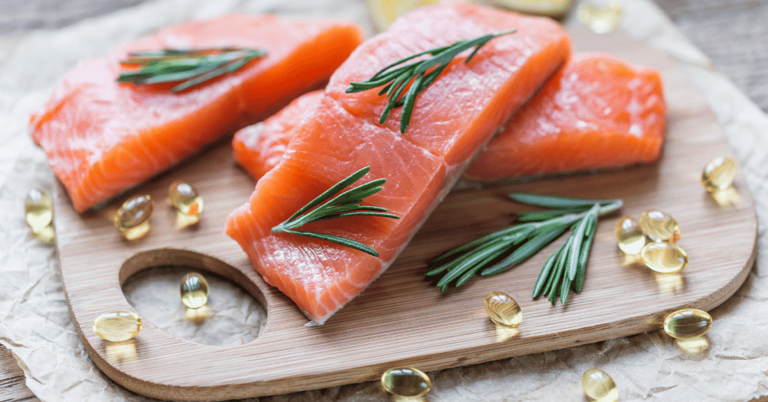 Fatty fish and omega-3 supplements on a wooden  cutting board.