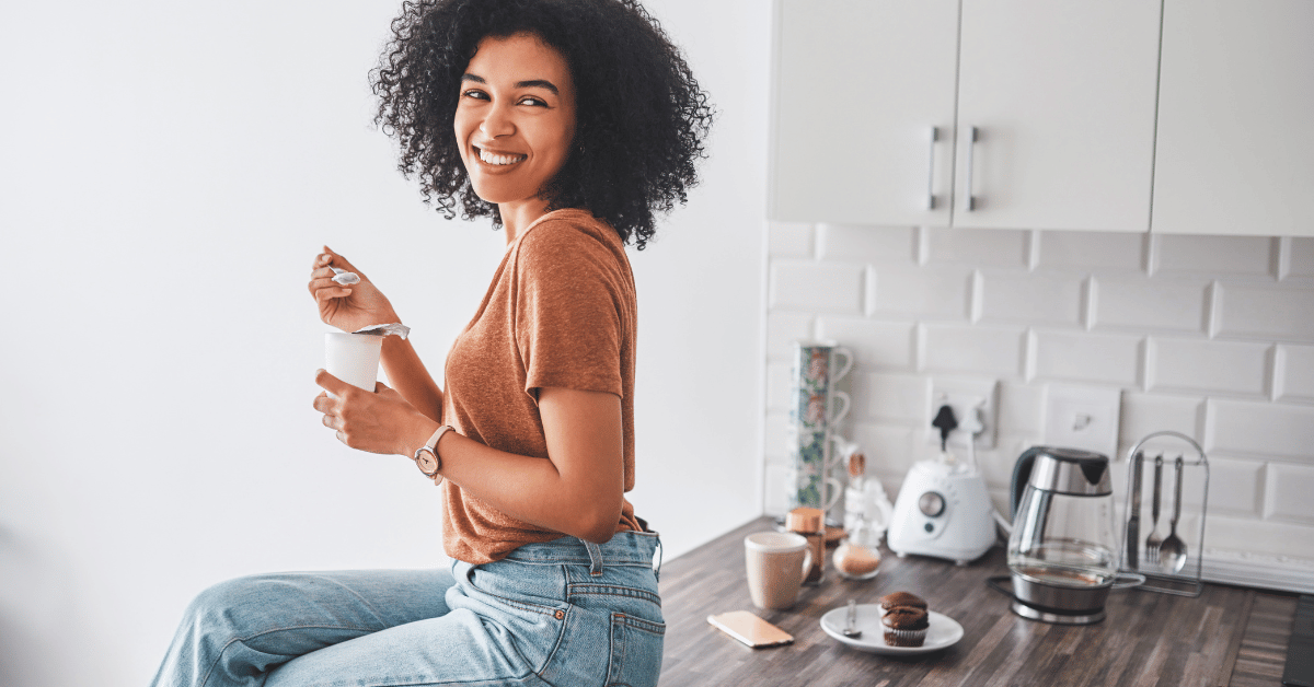 A woman holds a bowl of yogurt.