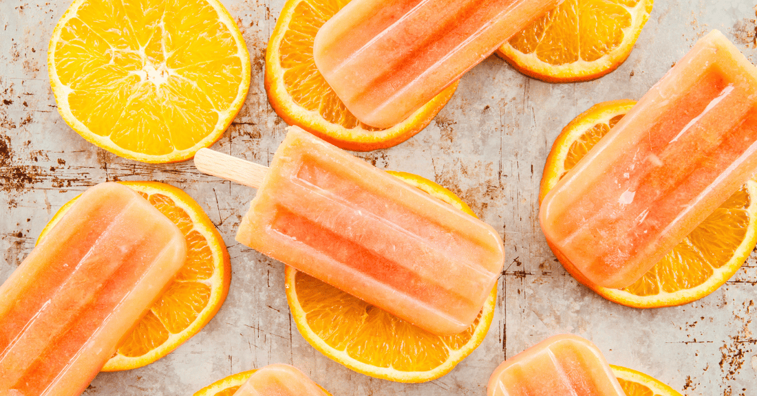 Homemade orange and honey popsicles with orange slices.