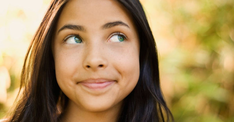 A teenage girl smiles.