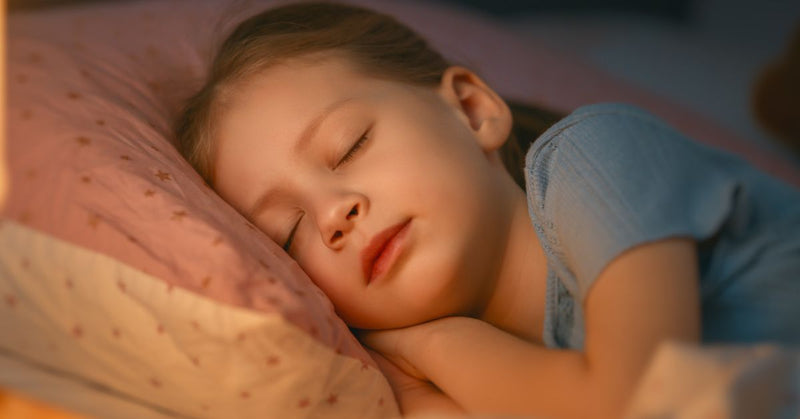 A girl sleeps peacefully in her bed.