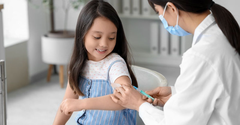 A girl gets a vaccine shot in her arm.